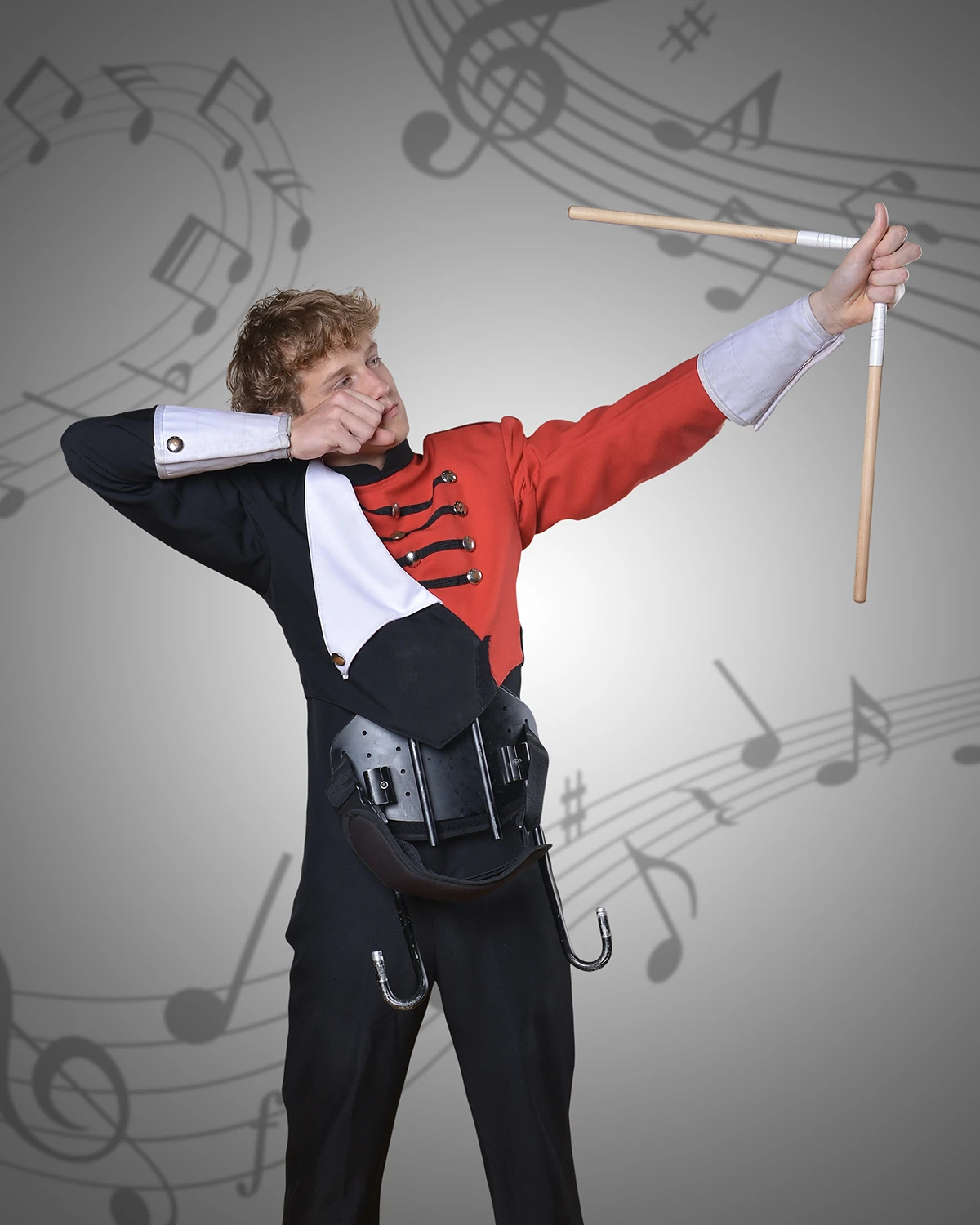 Portrait of young man holding drumsticks like a bow and arrow